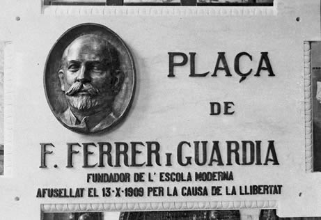 Placa da praça dedicada a Ferrer i Guàrdia. Na inscrição pode-se ler, em catalão, «fundador da Escola Moderna. Fuzilado a 13-10-1909 pela causa da liberdade»